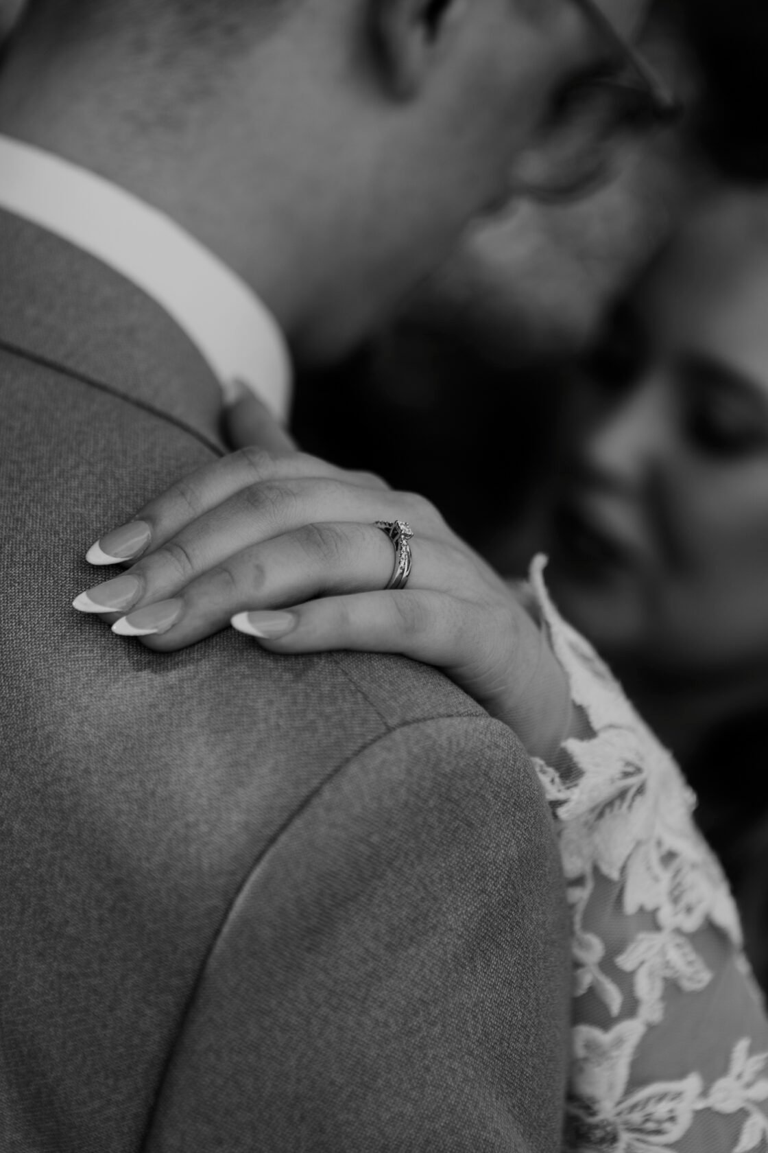 Bride embracing groom ring in black and white