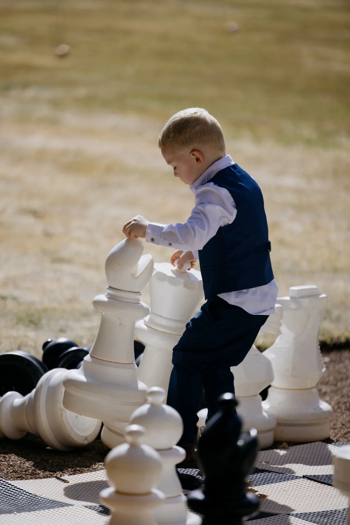 Young wedding guest playing giant chess