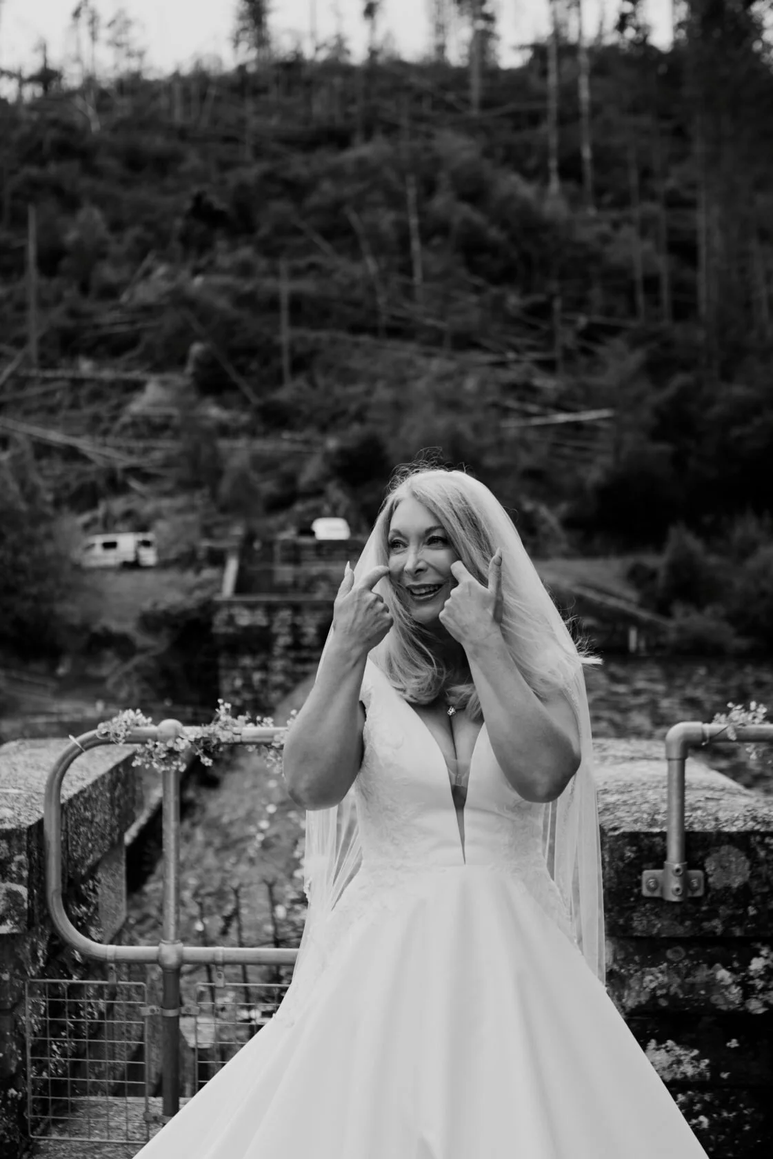 Bride smiling in a playful black-and-white veil portrait