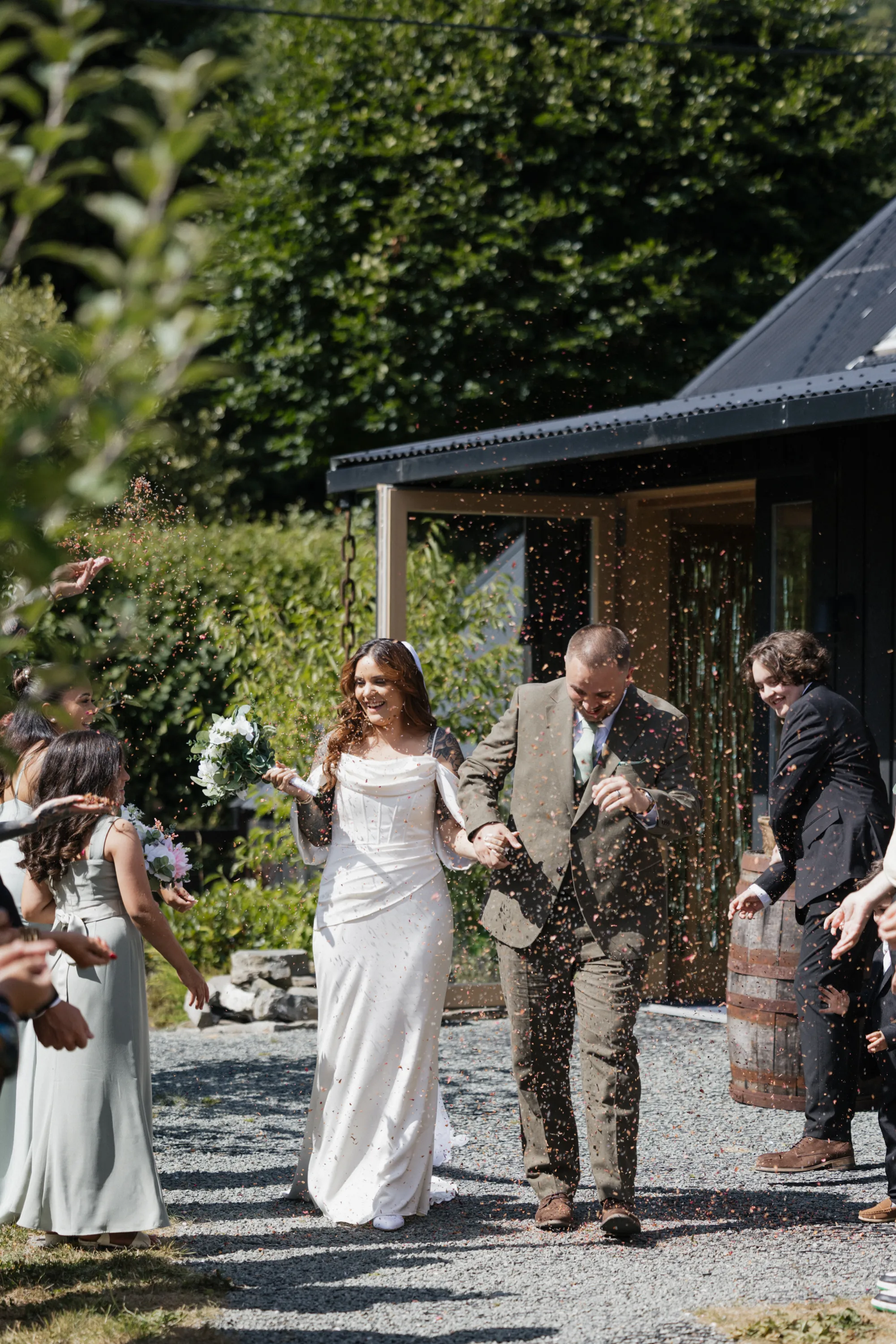 Autumn and Sebastian walking through confetti at Nant y Walch Barn