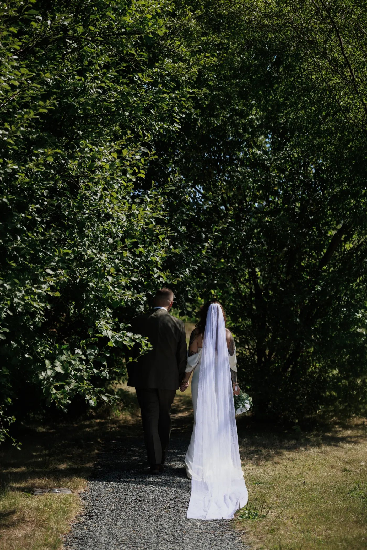 Newlyweds walking into the woodland at Nant y Walch Barn