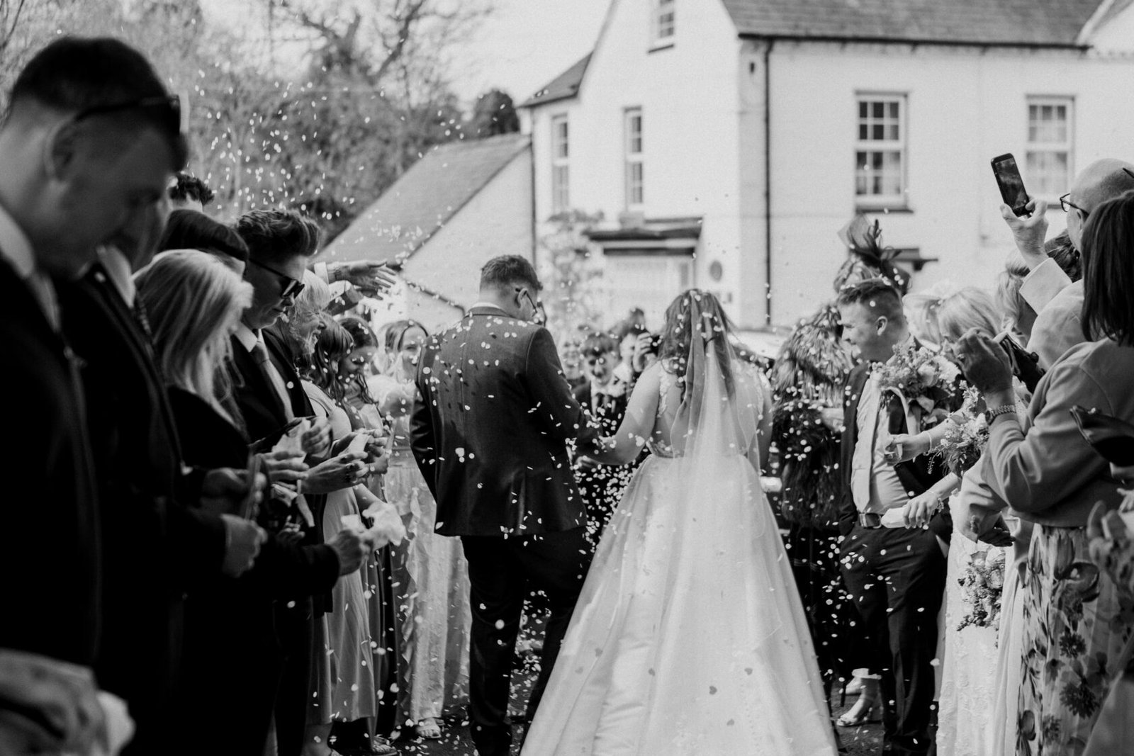 Newlyweds confetti exit in black and white