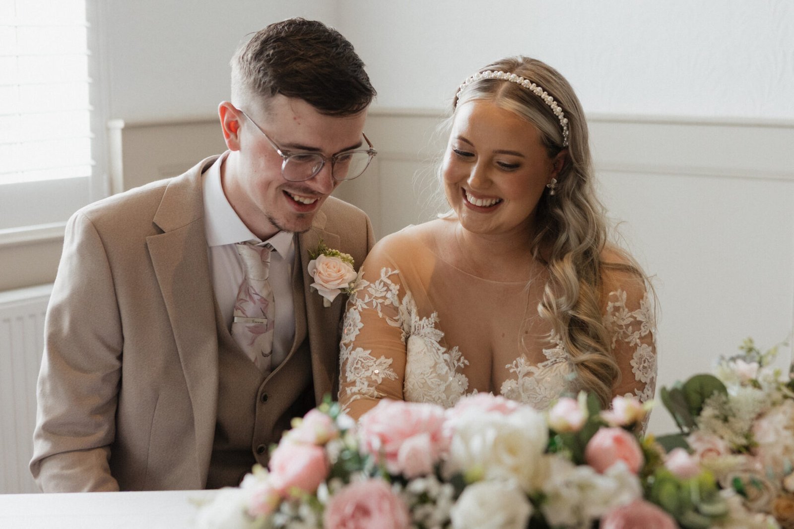 Newlyweds smiling ceremony table