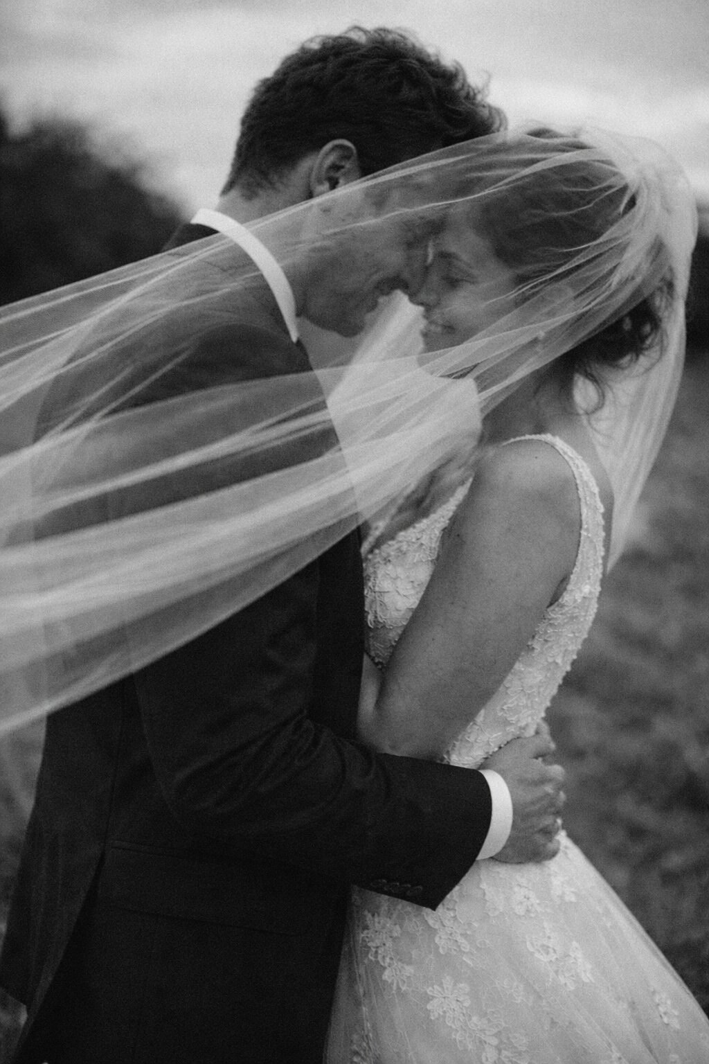 Newlyweds veil embrace in black and white