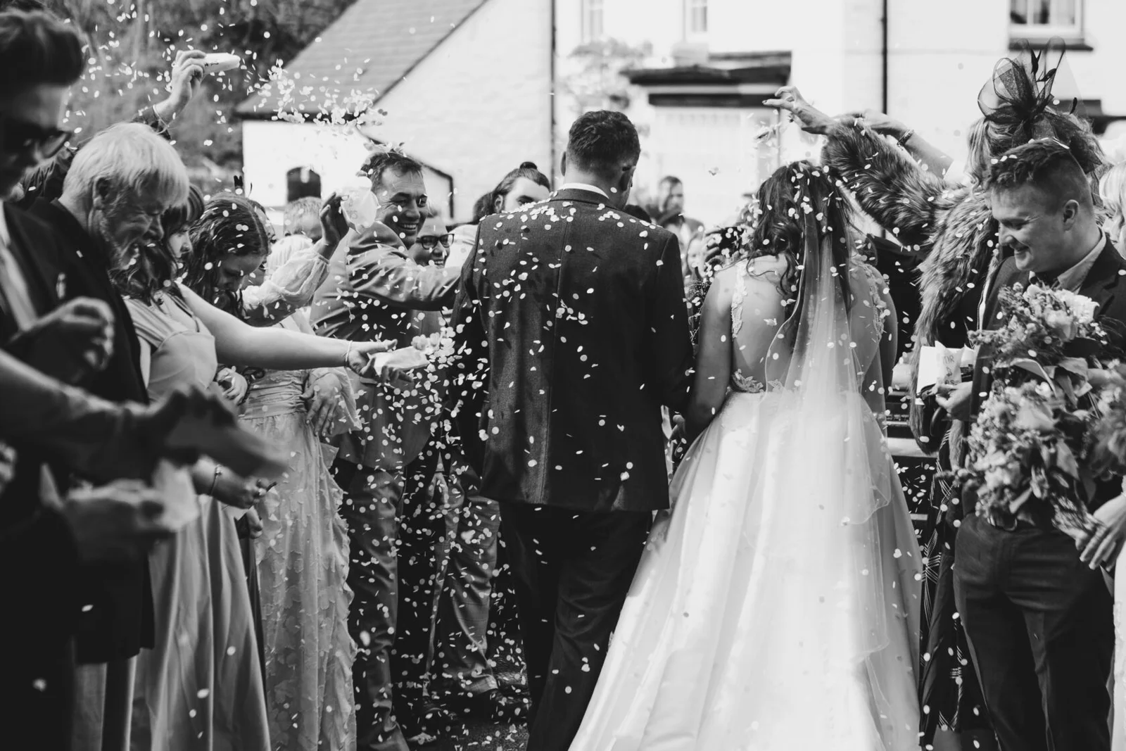 Newlyweds leaving their ceremony through falling confetti